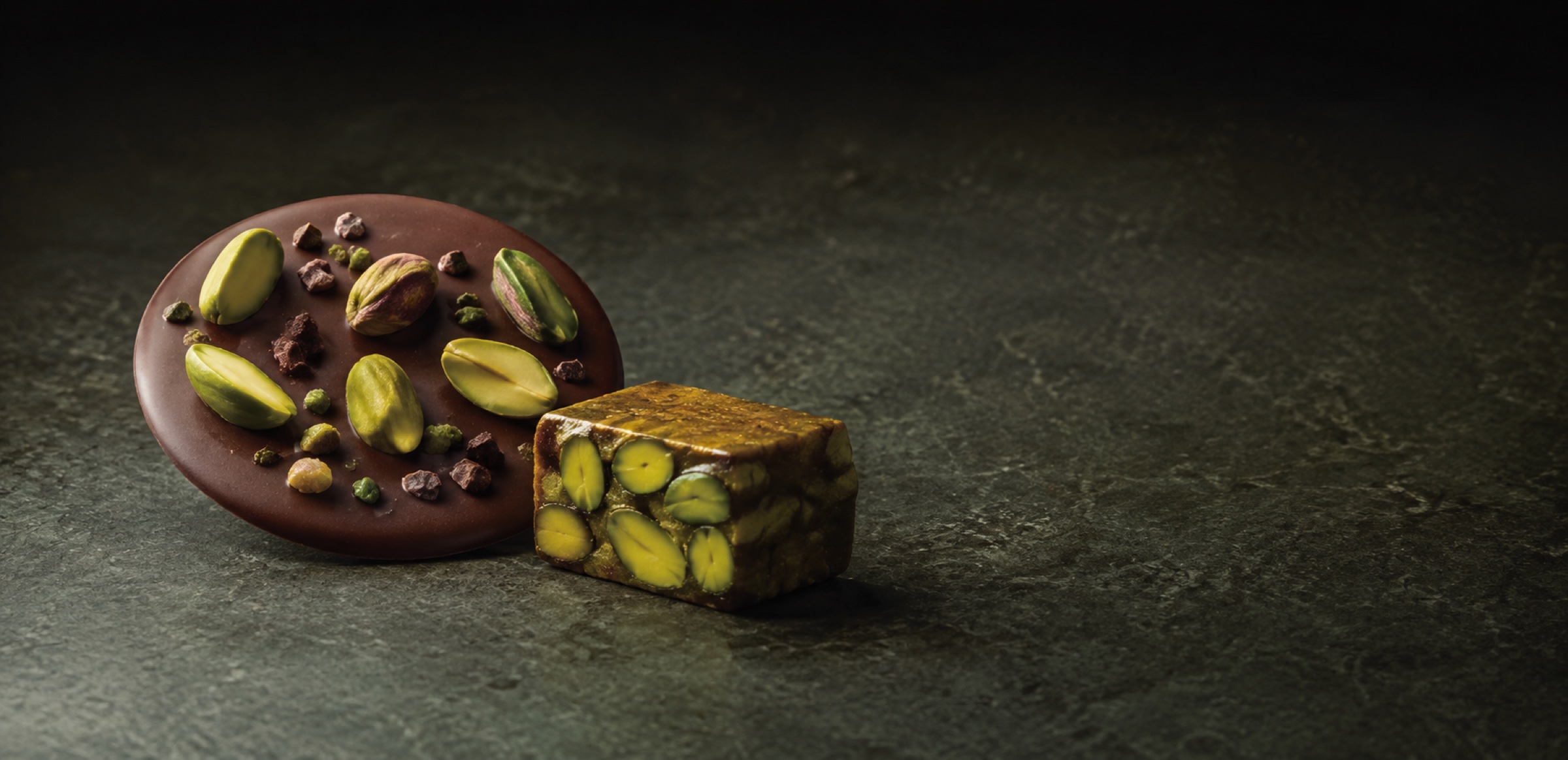Dark chocolate and premium confectionery featuring visible pistachio kernels